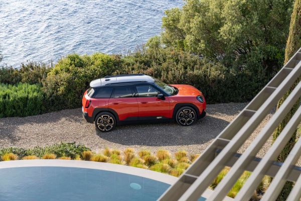 Orangener Mini Aceman steht an einem Pool an der Küste.