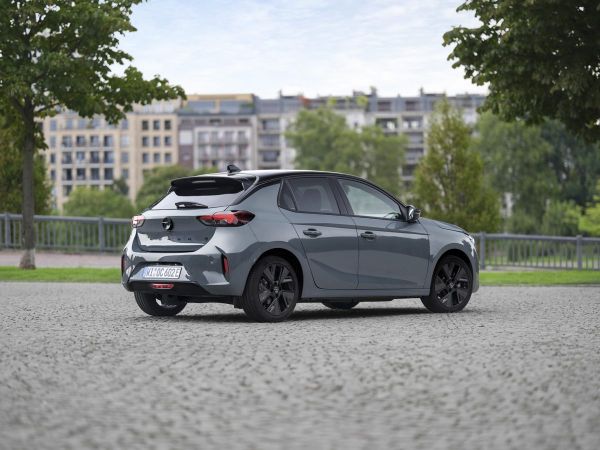 Der Opel Corsa Electric in der Seitenansicht auf einem Platz. Im Hintergrund sind Häuser.