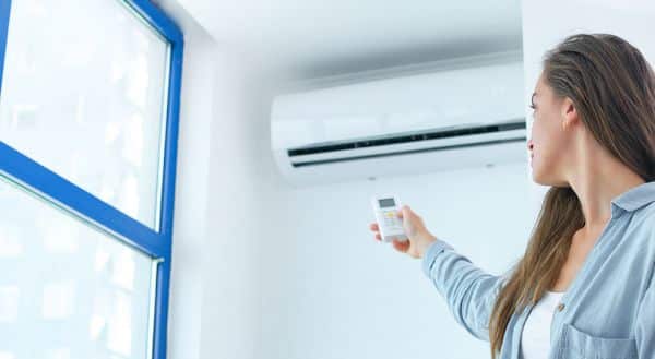 Frau schaltet Klimaanlage an