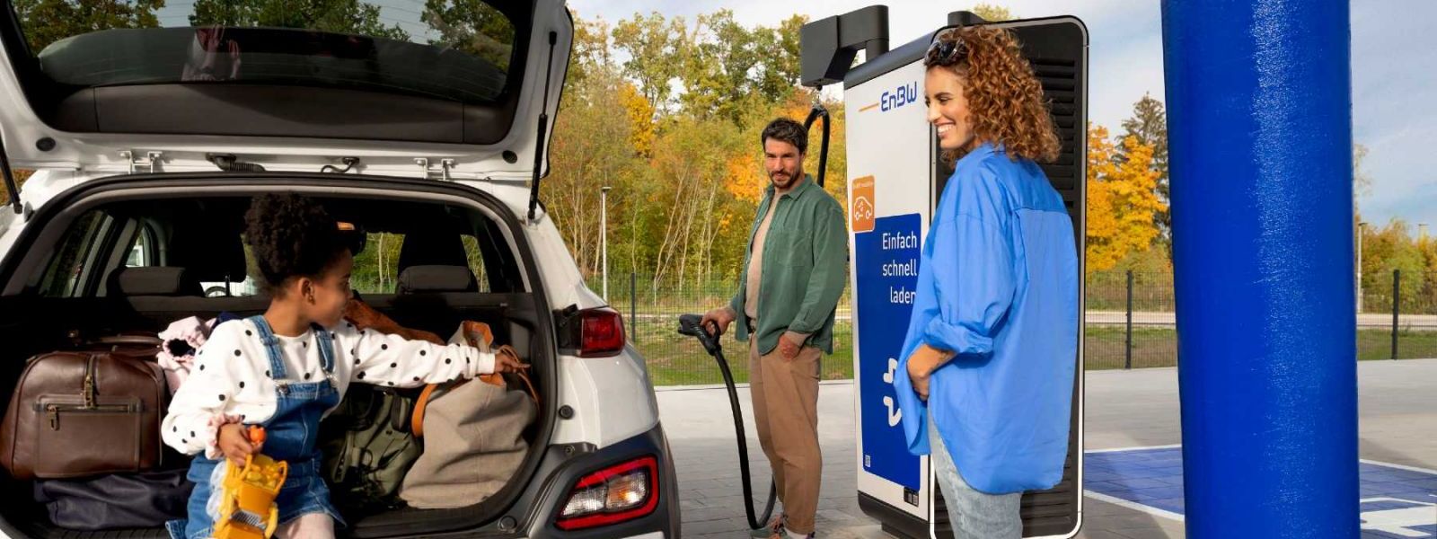 Eine Familie auf Urlaubsfahrt lädt ihr E-Auto an einem EnBW-Ladepark.