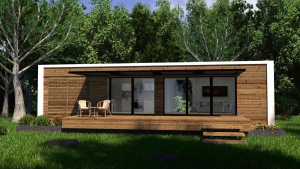 Tiny House aus Holz vor einem Wald.