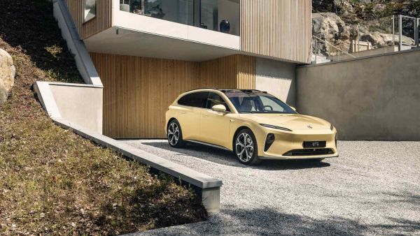 Nio et5 in gelb in der Einfahrt eines Hauses.