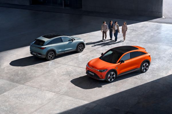 3 Smart #3 auf einer Betonfläche, daneben steht eine kleine Gruppe von Menschen.