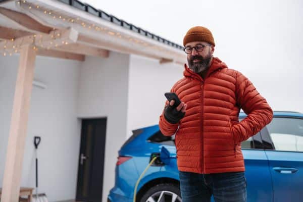 E-Auto wird im Winter vor dem Haus geladen