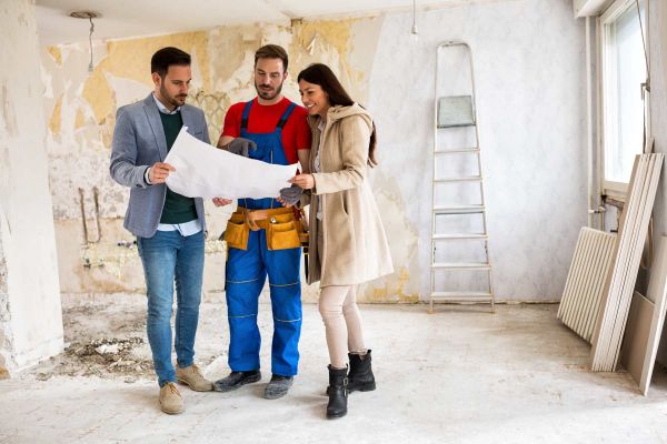 Bauherren und Handwerker bei einer Baubesprechung.