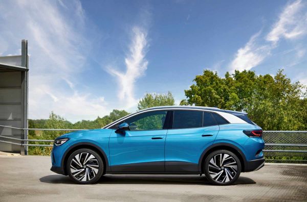 Der VW ID.4 auf einer Straße vor Bäumen