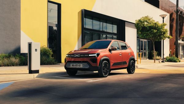 Roter Dacia steht vor einem gelben Haus.