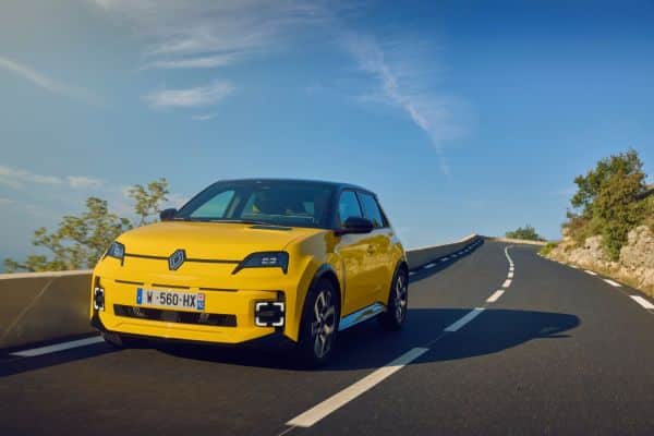 Gelber Renault fährt die Straße entlang unter blauem Himmel.