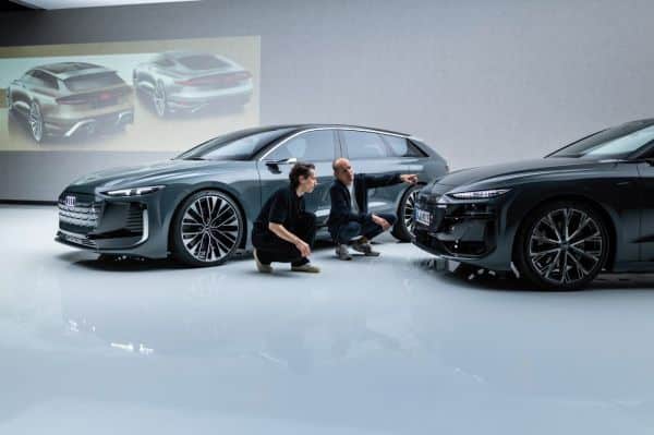 Zwei Männer knien vor dem Audi A6 Avant e-tron performance.