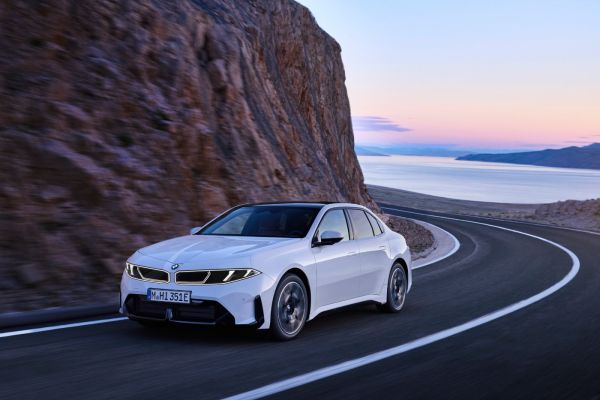 BMW i3 fährt vor einer Bergkulisse.