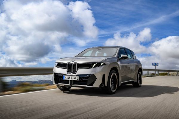 Der BMW iX3 50 xDrive fährt auf einer Straße.
